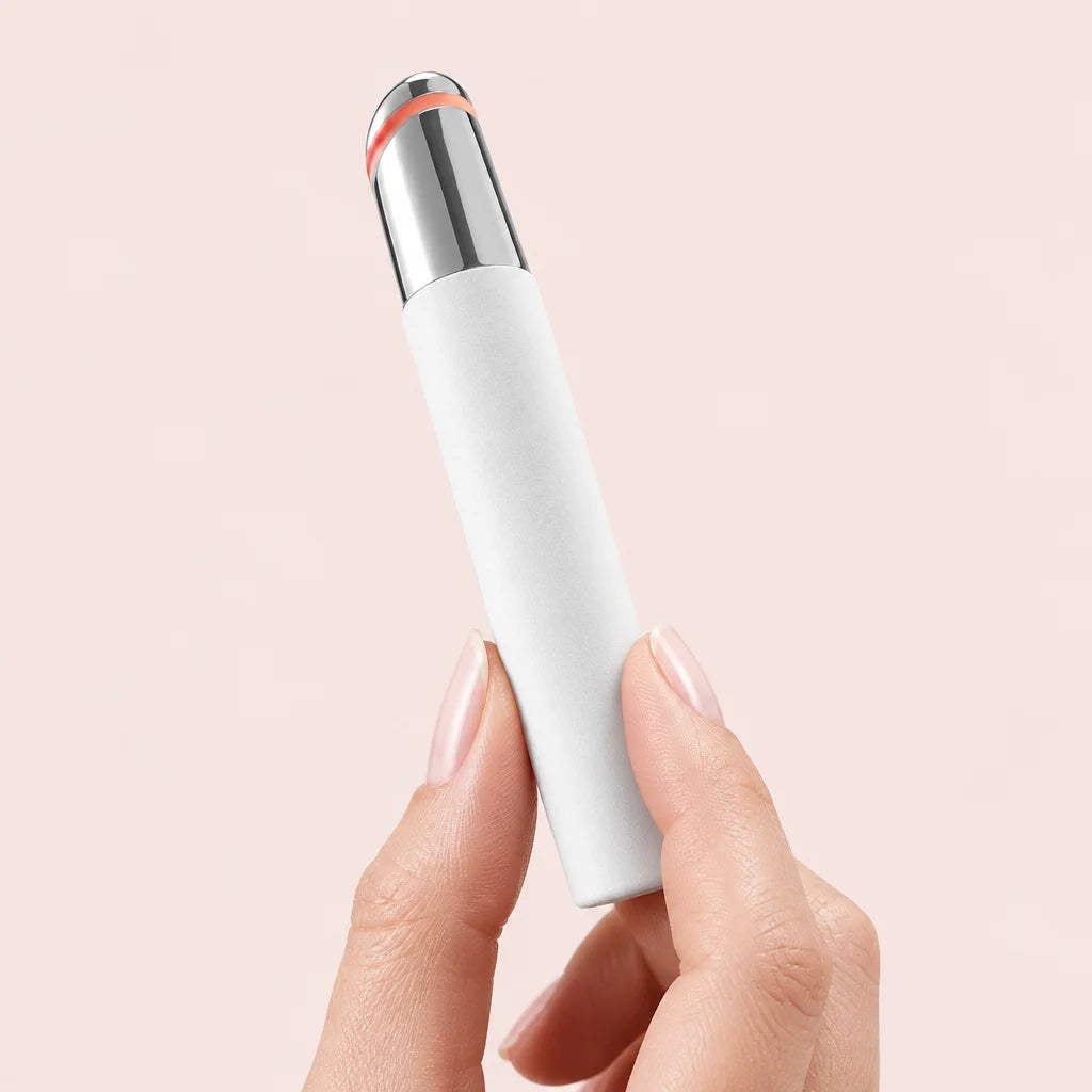 Photo produit premium en studio : Stylo Regard Lisse rose tenu délicatement entre deux doigts, gros