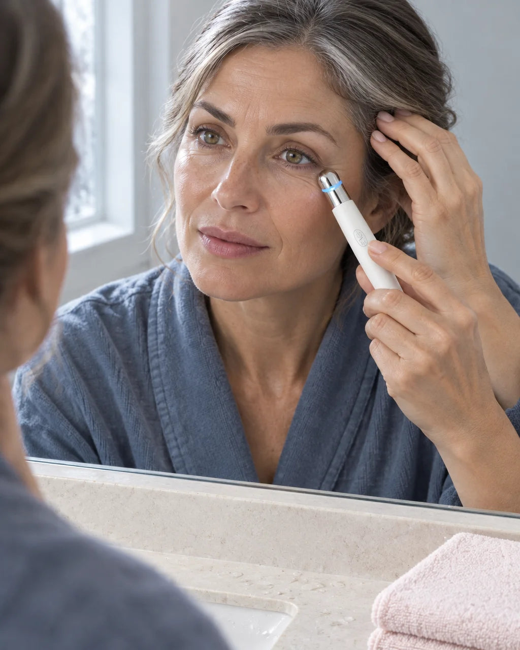 A photograph of the exact slim white eye-care wand from the reference: a gently tapered white body,